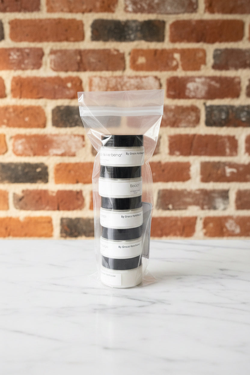 Stack of black and white striped bottles in clear plastic packaging on a marble surface.