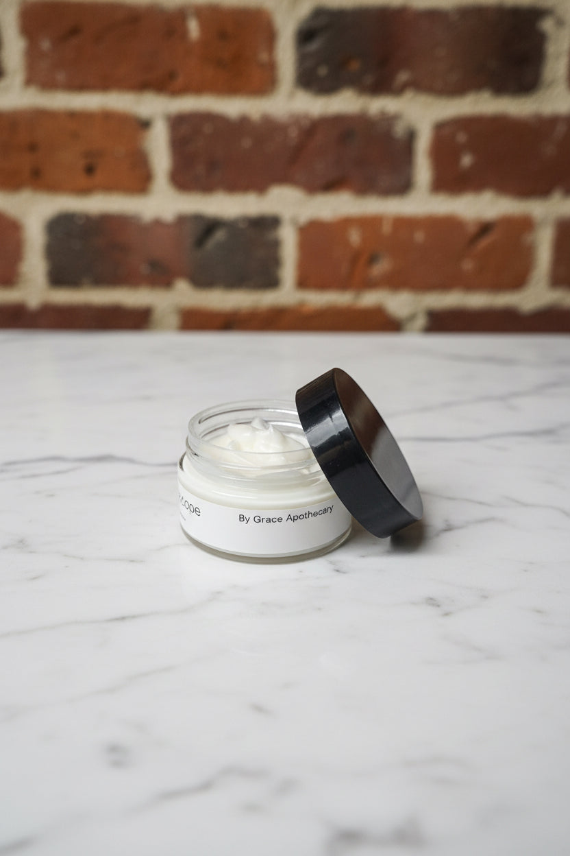 Small jar with black lid on a textured gray surface