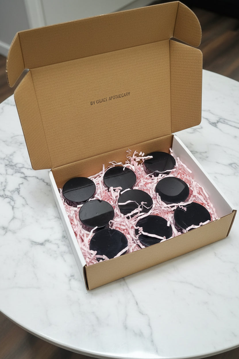 White box with 9 lotions sitting on a marble table.