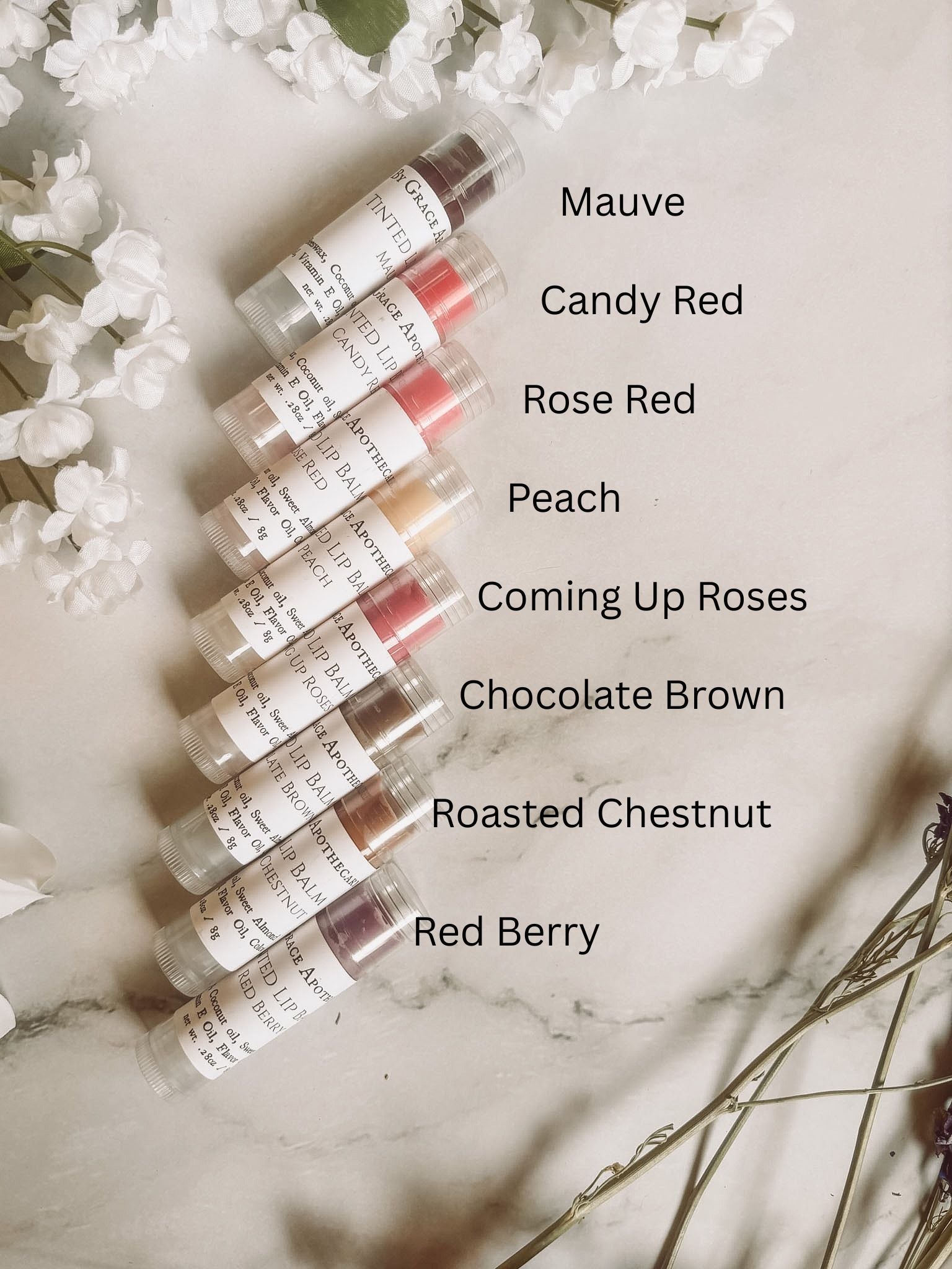 Set of lip color samples with labels on a marble surface.