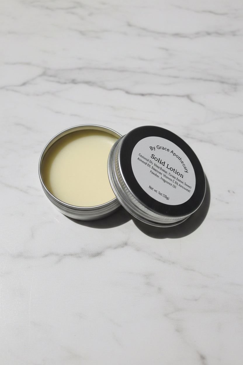 Solid lotion in a metal container with a black lid on a marble surface